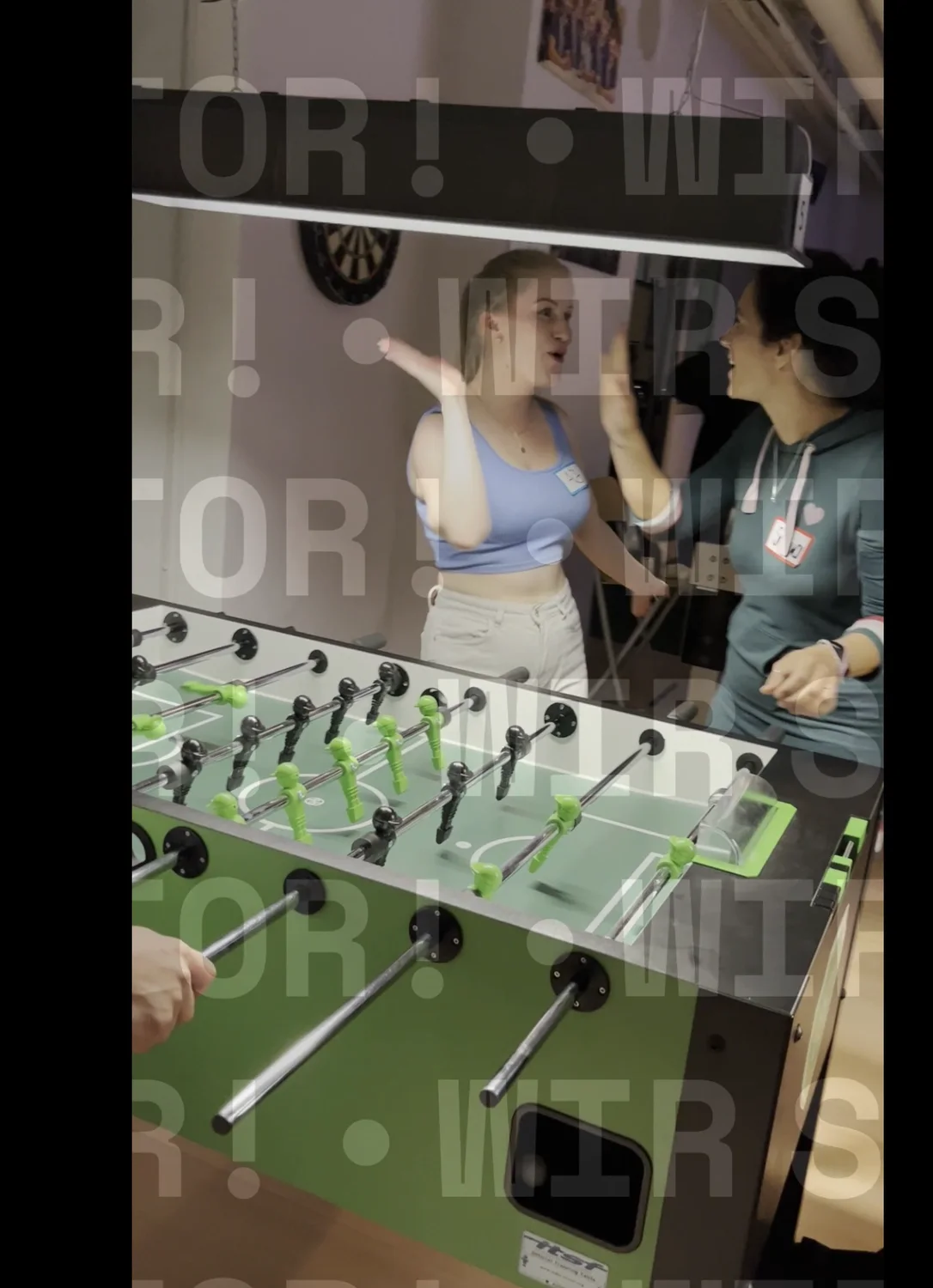 Videoausschnitt mit zwei Gästen am grünen Kickertisch