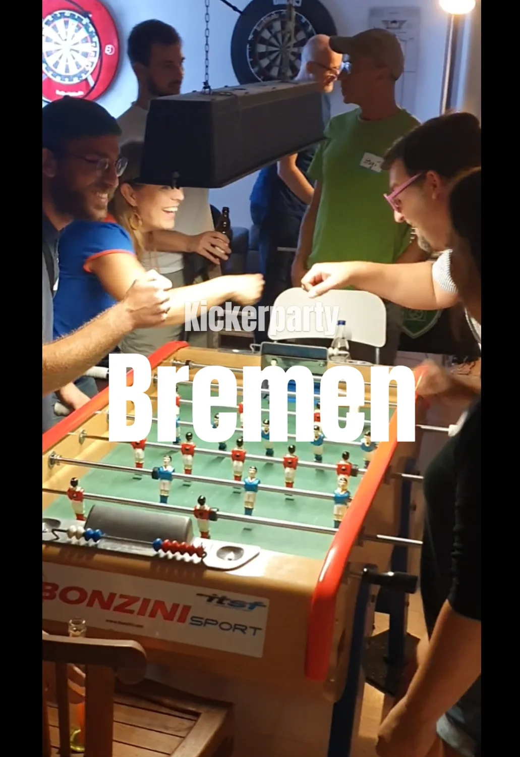 Lachende Spielerinnen und Spieler am Kickertisch in einem Videoausschnitt